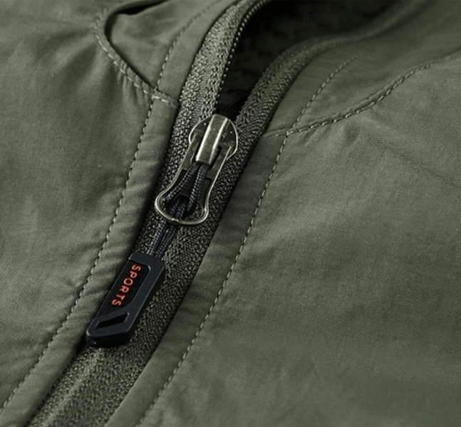 Close-up of green nylon quick-dry waistcoat zipper from men's sleeveless multi-pocket vest, style SF1161, with 'Sports' tag